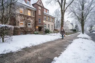 Geräumter und gestreuter Gehweg vor einem Mehrfamilienhaus in Köln im Winter